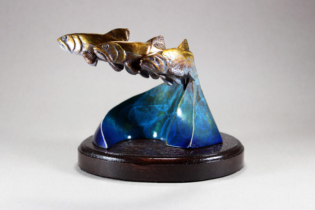 An abstracted sculpture of 3 Bronze Salmon migrating upstream